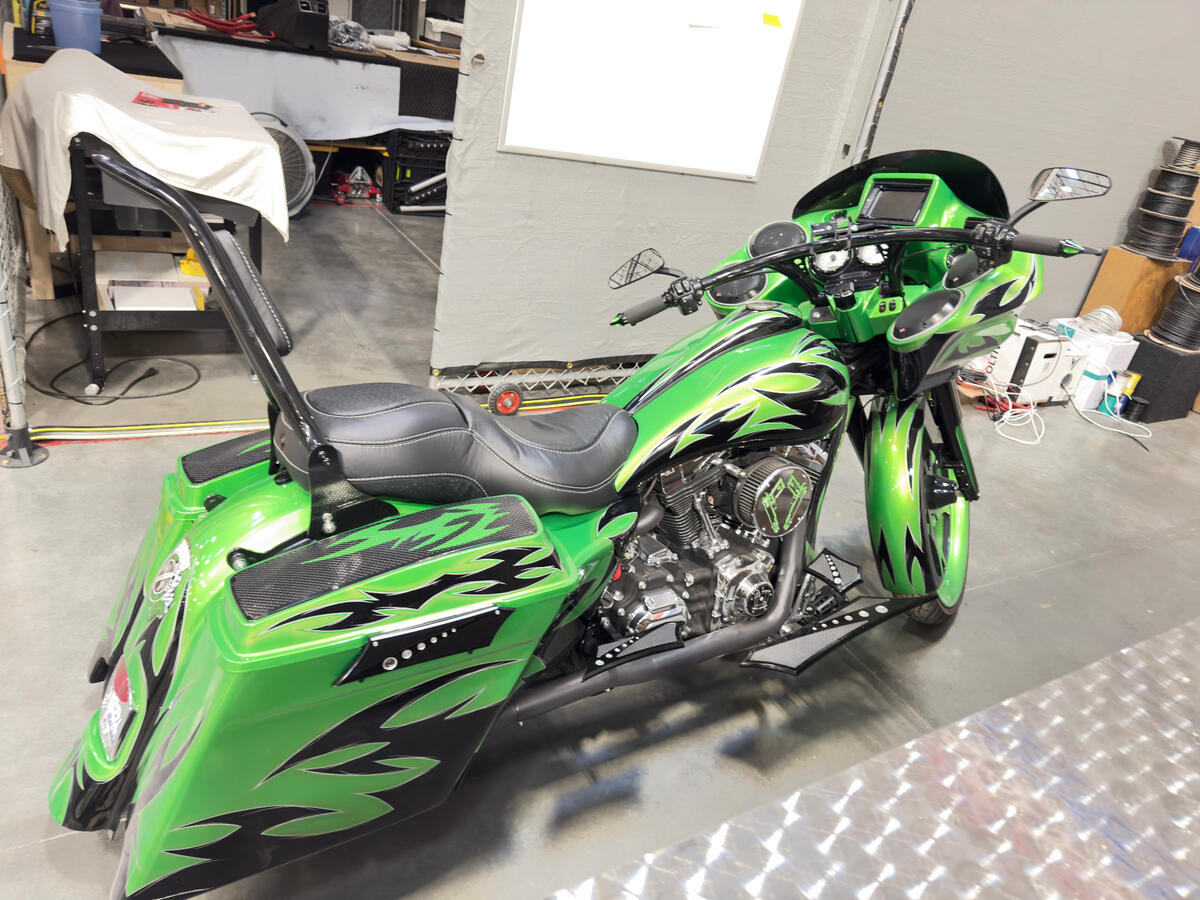 Custom green Harley-Davidson bagger with flame graphics - side view