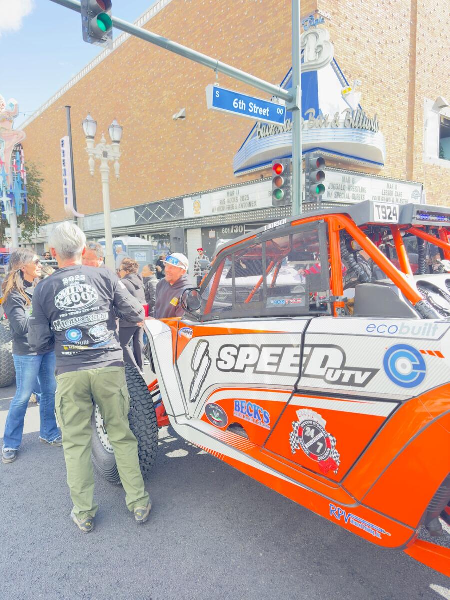 Speed UTV side view with sponsor decals at Mint 400